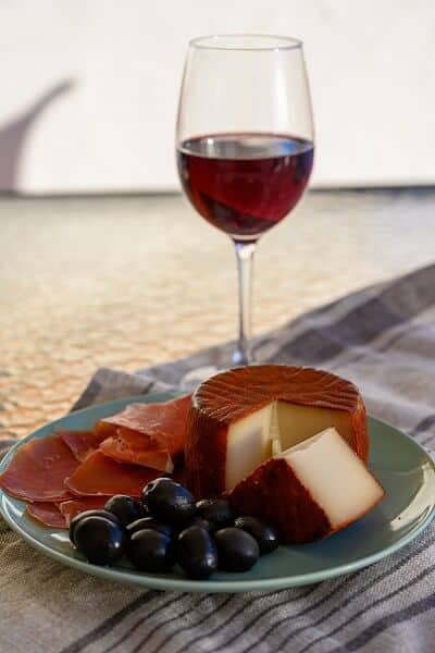 Glass of Rioja Wine with Plate of Manchego Cheese and Spanish Snacks