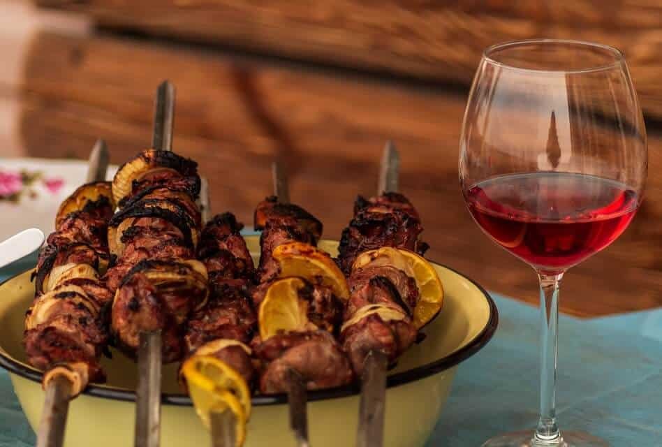 Dish of Meat Skewers with Glass of Red Wine
