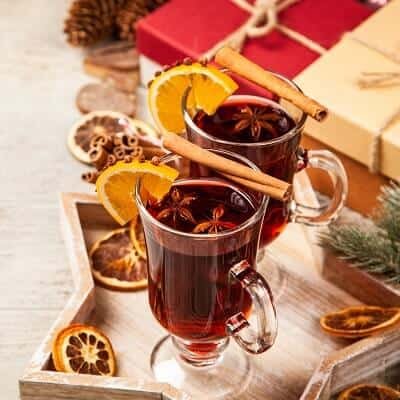 Two Glasses of Mulled Wine with Cinnamon Sticks and Orange Slices